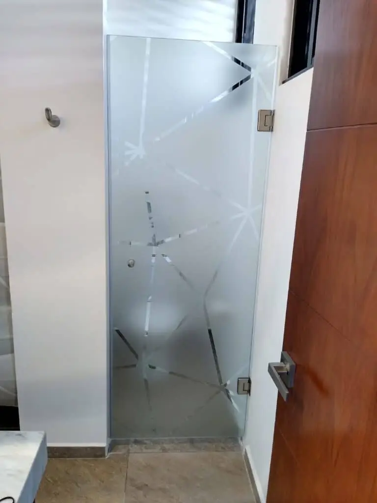 Puerta de vidrio esmerilado con diseño decorativo en oficina moderna.
